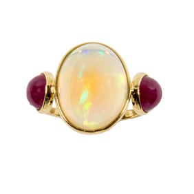 An opal, ruby, and 18k gold ring