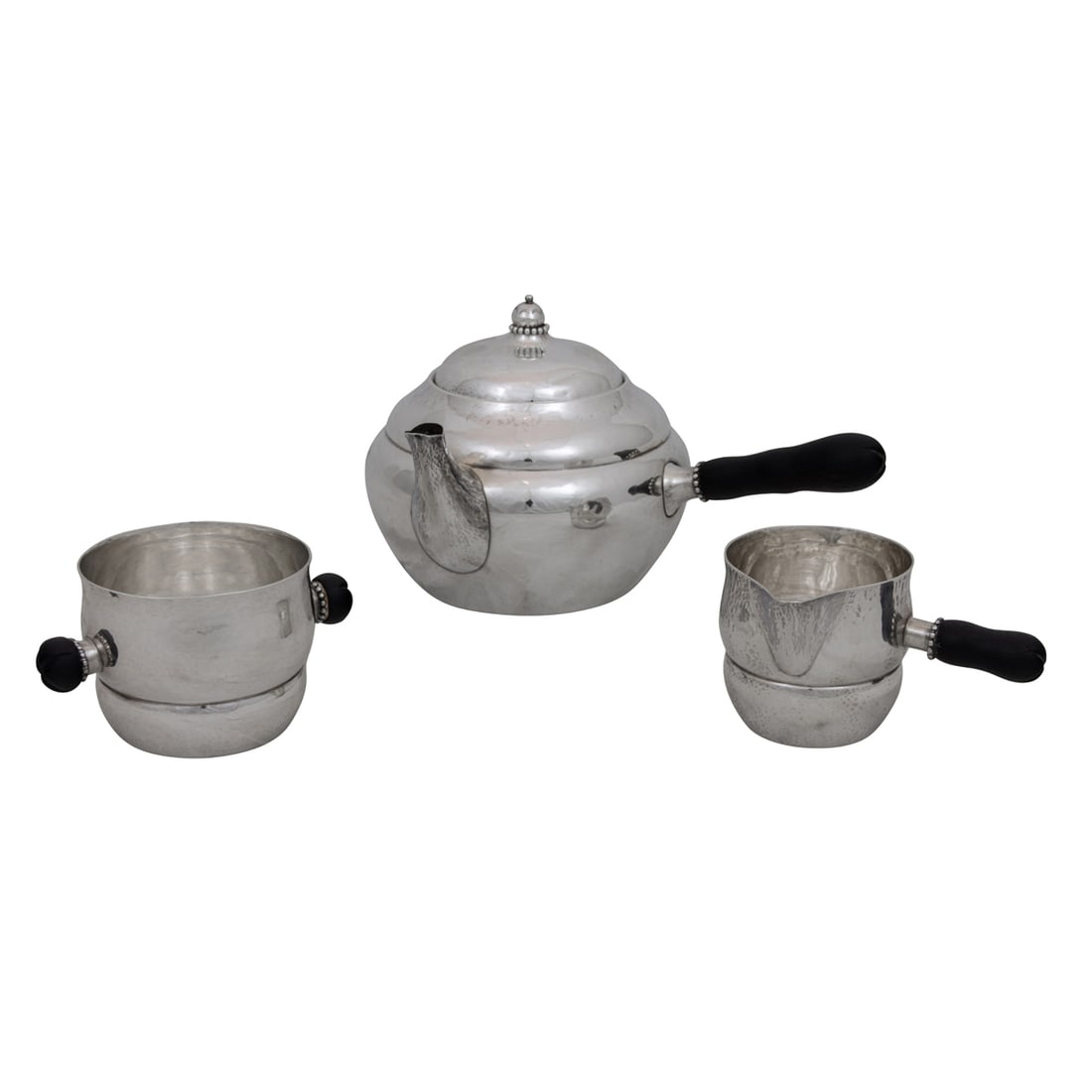 A Georg Jensen sterling three piece tea set with ebony handles: A Georg Jensen sterling three piece tea set with ebony handles, comprising teapot, sugar bowl, and cream pitcher, each with beaded ball finial, greatest 4.75"h x 8.5"w, 19.54 oz troy including handles