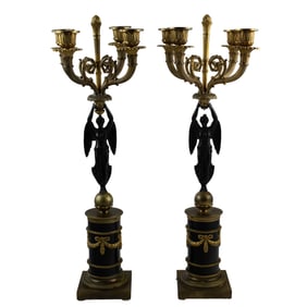A pair of Empire style gilt and patinated bronze figural four-light candelabra