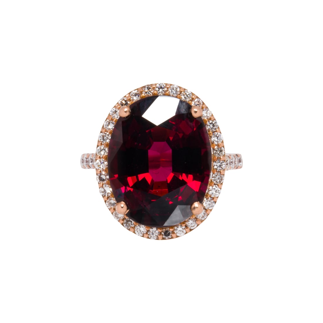 A garnet, diamond, 14k and 18k gold ring: A garnet, diamond, 14k and 18k gold ringCentering an oval-cut garnet weighing 11.20 carats, framed by a halo of 39 round brilliant-cut diamonds; size 5 3/4; 6.65 grams