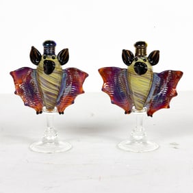 A pair of hand-blown multicolor glass bat form salt and pepper shakers