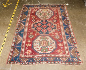 An antique Kazak area rug (wear)