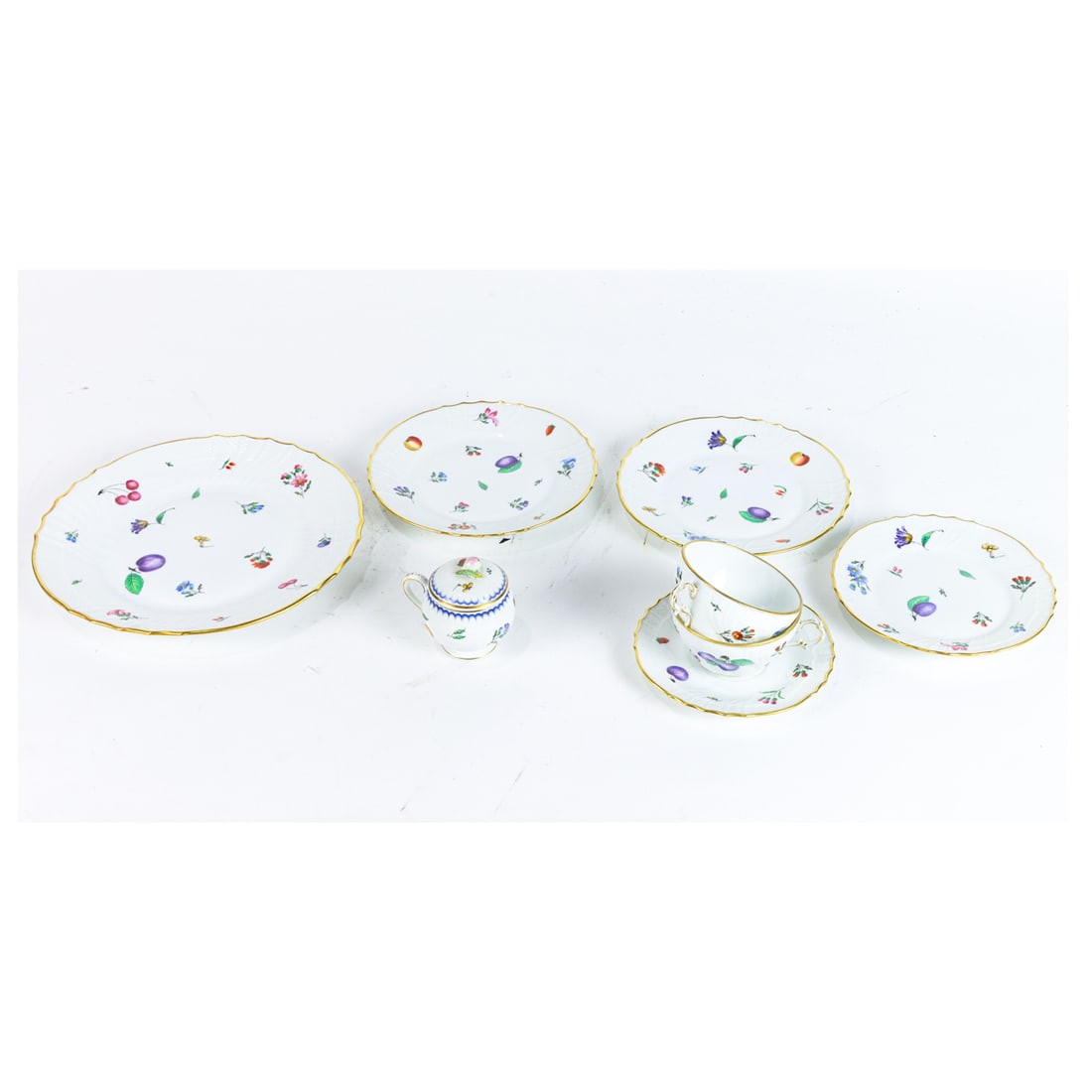 A Ginori porcelain dinner service in the Perugia pattern: A Ginori porcelain dinner service in the Perugia pattern, each decorated with fruits and flowers within a gilt rim, comprising (20) dinner plates, 10.25"dia; (19) plates, 7.75"dia; (16) plates, 6.75"d