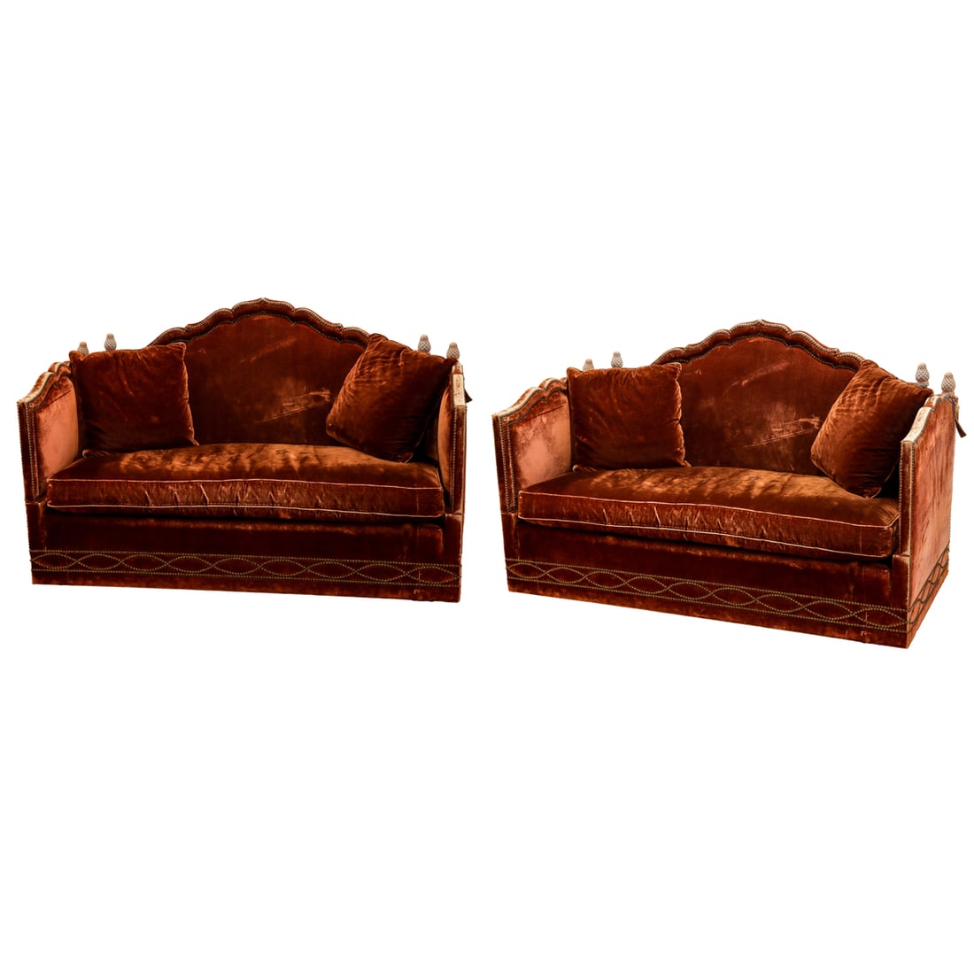 A pair of Knole sofas upholstered in burgundy/rust velvet: A pair of Knole sofas upholstered in burgundy/rust velvet with nailhead trim, both ends drop to convert to daybeds. Each retains Baker Furniture labels under the drop in cushion seats, 39.5"h x 61.5"l