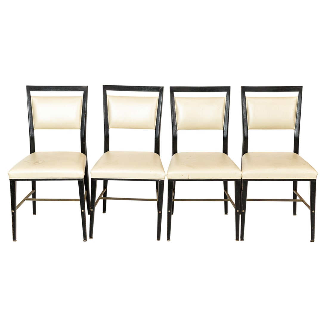 A set of four Paul McCobb for Calvin ebonized mahogany dining chairs: A set of four Paul McCobb for Calvin ebonized mahogany dining chairs, each with ivory leather upholstery, raised on tapering legs joined by brass stretchers, 36.5"h x 18.5"w x 19"d; seat 19"h