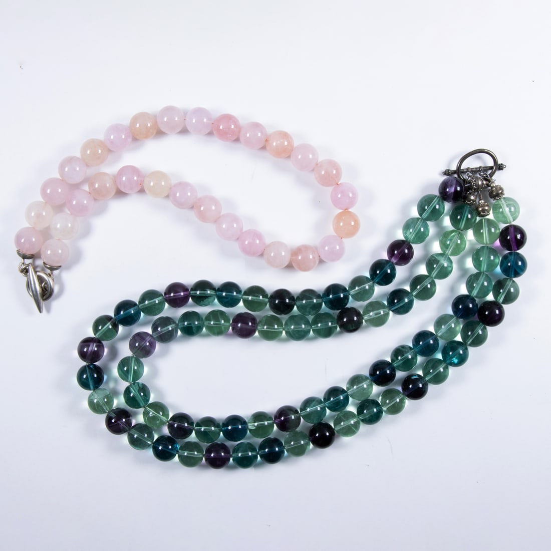 Two semi-precious stone and silver beaded necklaces: Two semi-precious stone and silver beaded necklaces Comprising one double stranded necklace of round-shaped tourmaline beads measuring 13.61 mm, together with a strand of round-shaped rose quartz bead