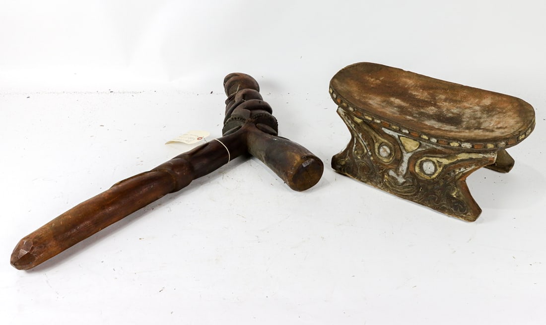 An Oceanic head rest and ceremonial club: An Oceanic head rest and ceremonial club, the headrest or stool, possibly Papua New Guinea, the sides carved with stylized face, 8.5"h x 19.5"l; the T-shaped club carved with figures, 33"h x 20"w [2 t