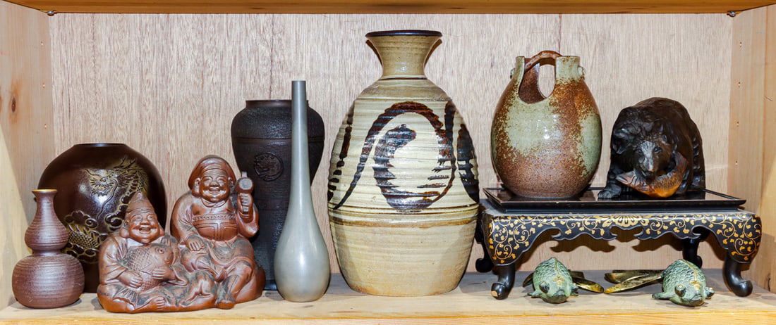 A shelf of Japanese ceramic and metal decorative objects: A shelf of Japanese ceramic and metal decorative objects. 20th century, 12" tallest.