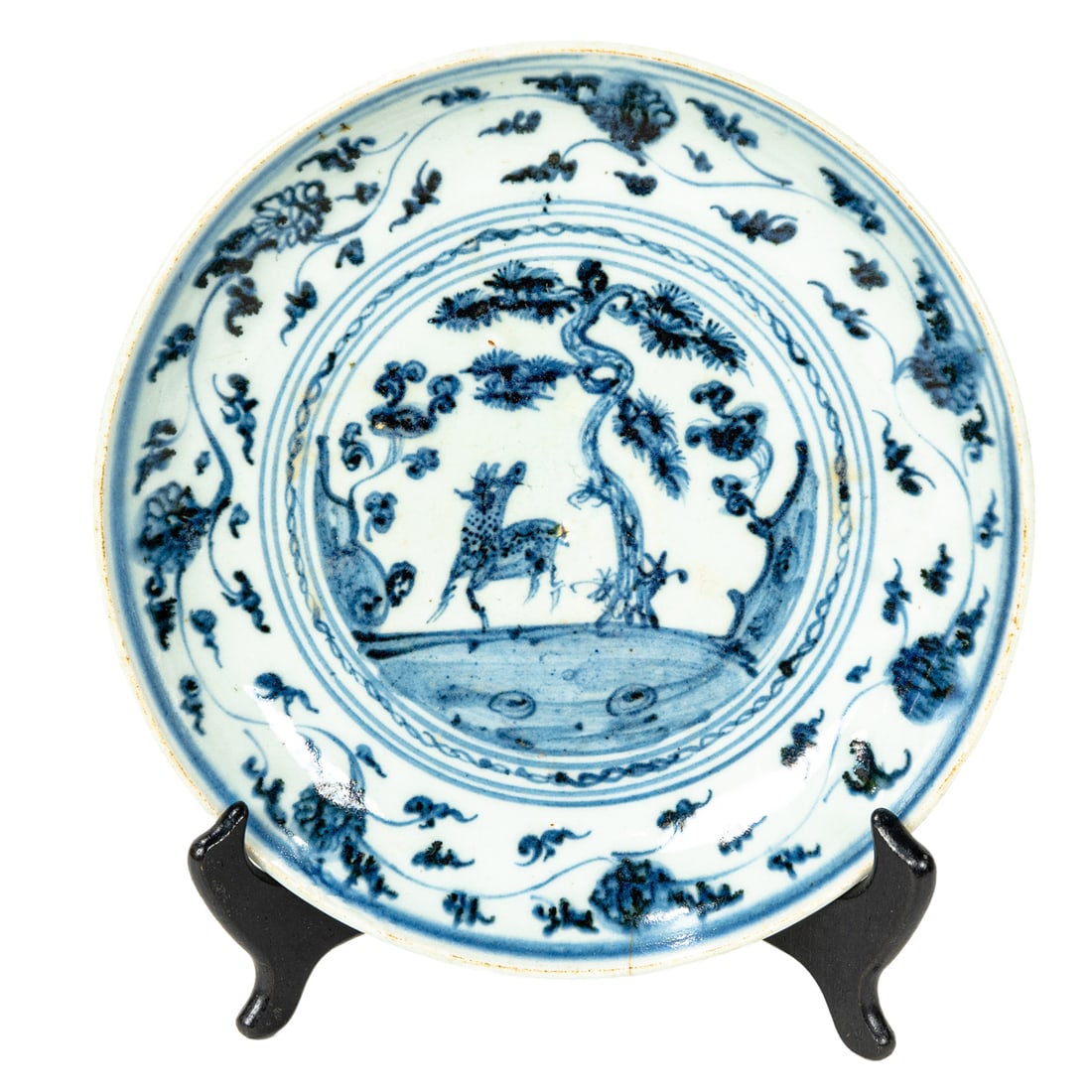 A Chinese blue and white 'deer and pine' dish: A Chinese blue and white 'deer and pine' dish. Featuring a central medallion painted with landscape scene depicting deer beside pine tree, 16th century, 9.5" across.