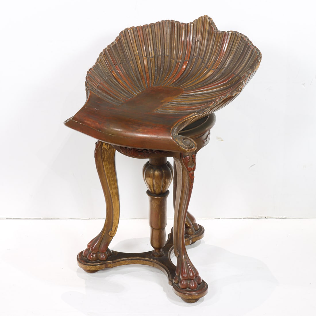 An Italian carved Grotto music stool early 20th century: An Italian carved Grotto music stool early 20th century, the shell form swivel seat resting on the tripod base ending on paw feet , 24"h x 16"w x 18"d