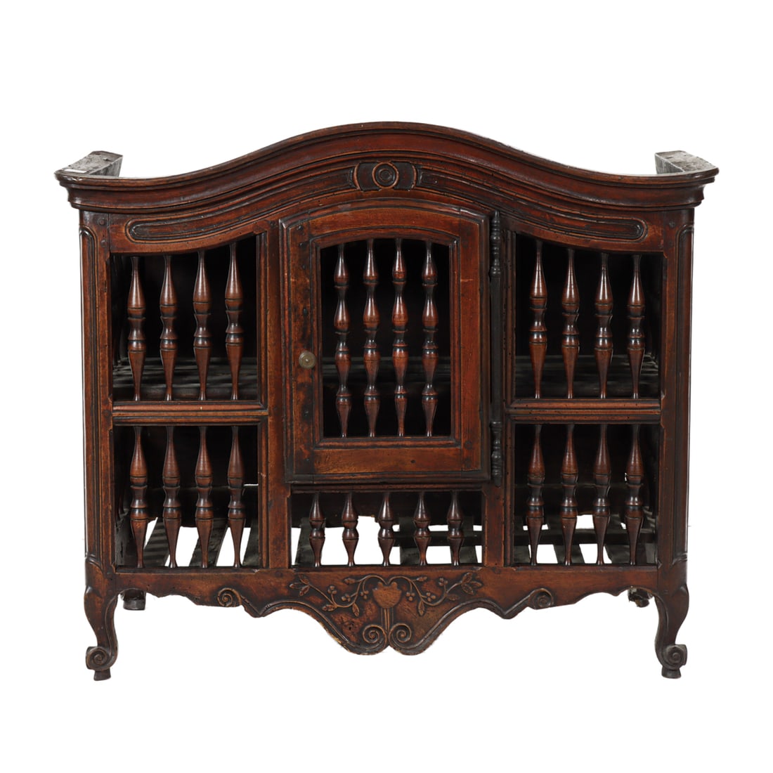 A French Provincial panettiere circa 1800: A French Provincial panettiere circa 1800, with a dome top above the spindle turned case having a single door, above the floral carved medallion, and rising on outswept legs, 37"h x 43"w x 23"d