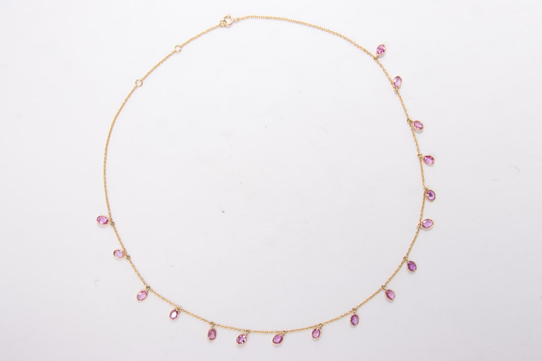 A pink sapphire and 18k gold necklace: A pink sapphire and 18k gold necklaceDesigned with 17 oval-cut pink sapphires suspended from cable-link chain; total sapphire weight: 4.85 carats; length: 18 in; 4.20 grams