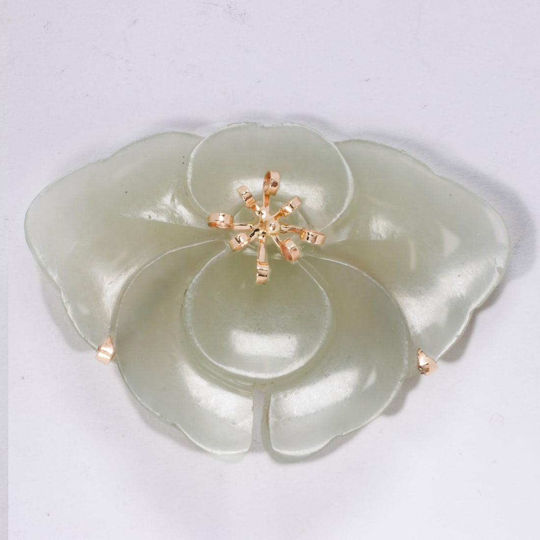 A Ming's jade and 14k flower brooch: A Ming's jade and 14k flower broochDesigned as a flower, mounted in 14k gold; width: 2 1/8 in; 12.65 grams