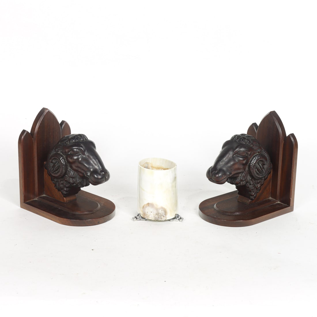 An assembled group of table decorations: An assembled group of table decorations, comprising a pair of European carved ram's head architectural elements, now mounted as bookends, overall 8"h x 5"w x 7"d; and a silver mounted horn cup, 4.25"h
