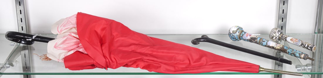 Three parasol handles and a parasol: Three parasol handles and a parasol, comprising silver gilt mounted porcelain handle painted figures, 5.5"l; Continental guilloche enamel and silver handle, 9.75"l; L-shaped wood handle and parasol