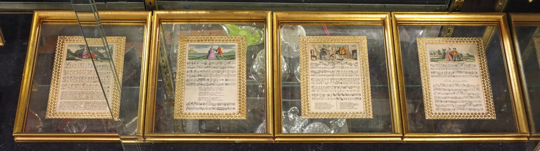 A set of four vintage music sheets: A set of four vintage music sheets, each sheet within Hollywood Regency style mirrored matt and giltwood frames, inscribed on back 'Styled and Framed for Neiman-Marcus Co., Dallas, Texas', overall