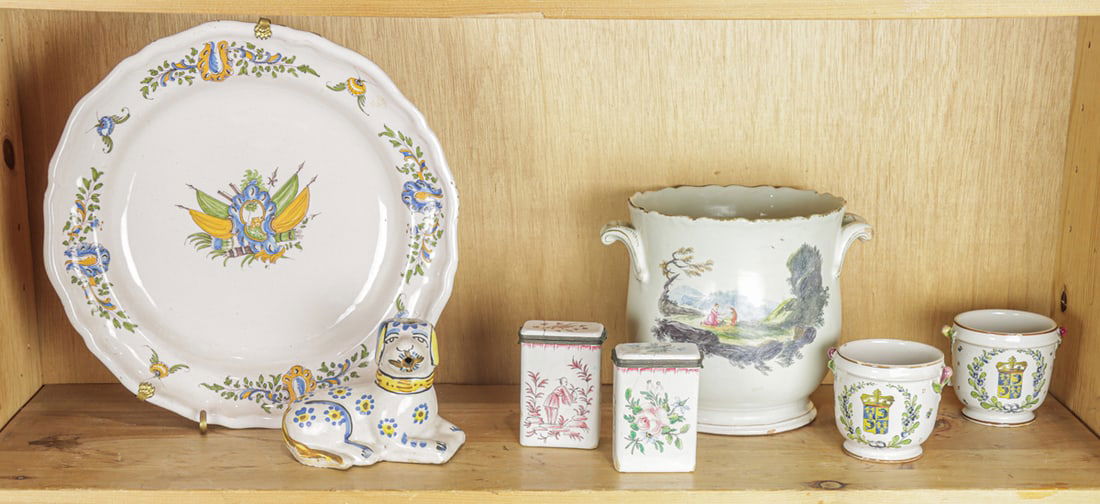 Seven pieces of faience: Seven pieces of faience, 19th/20th century, comprising charger, 12.75"l; pair of tea canisters, 3.75"h; recumbent dog; pair of miniature cache pots, 3.5"h and jardinere with landscape, 7"h. Provenance