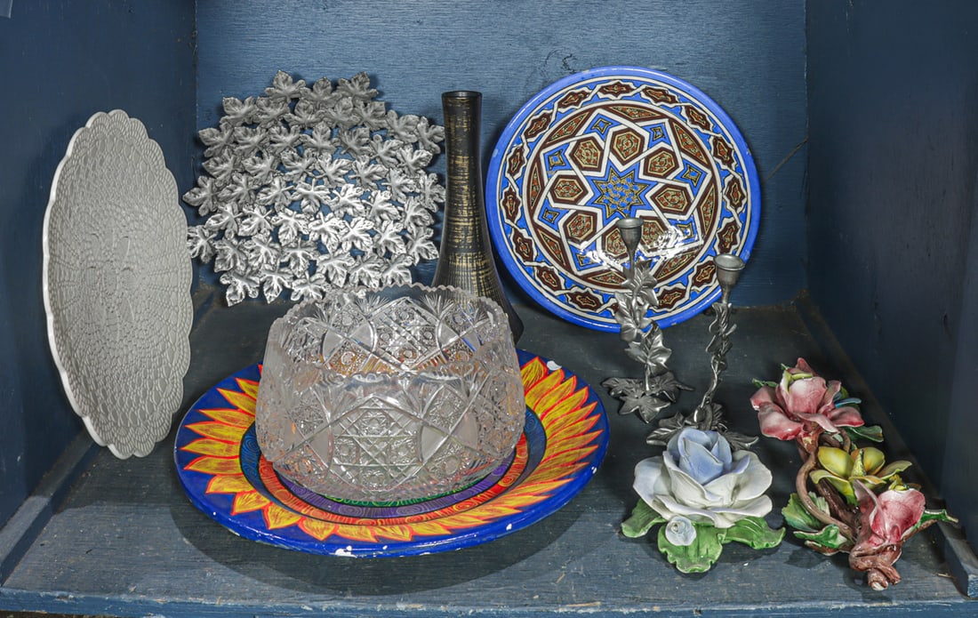 An assembled group: An assembled group, including a pair of metal candlesticks, leaf form bowl, McCoy vase, 12.5"w; cut glass bowl; Jerusalem pottery low bowl, 13.5"dia; (2) platters and (2) Italian pottery flowers