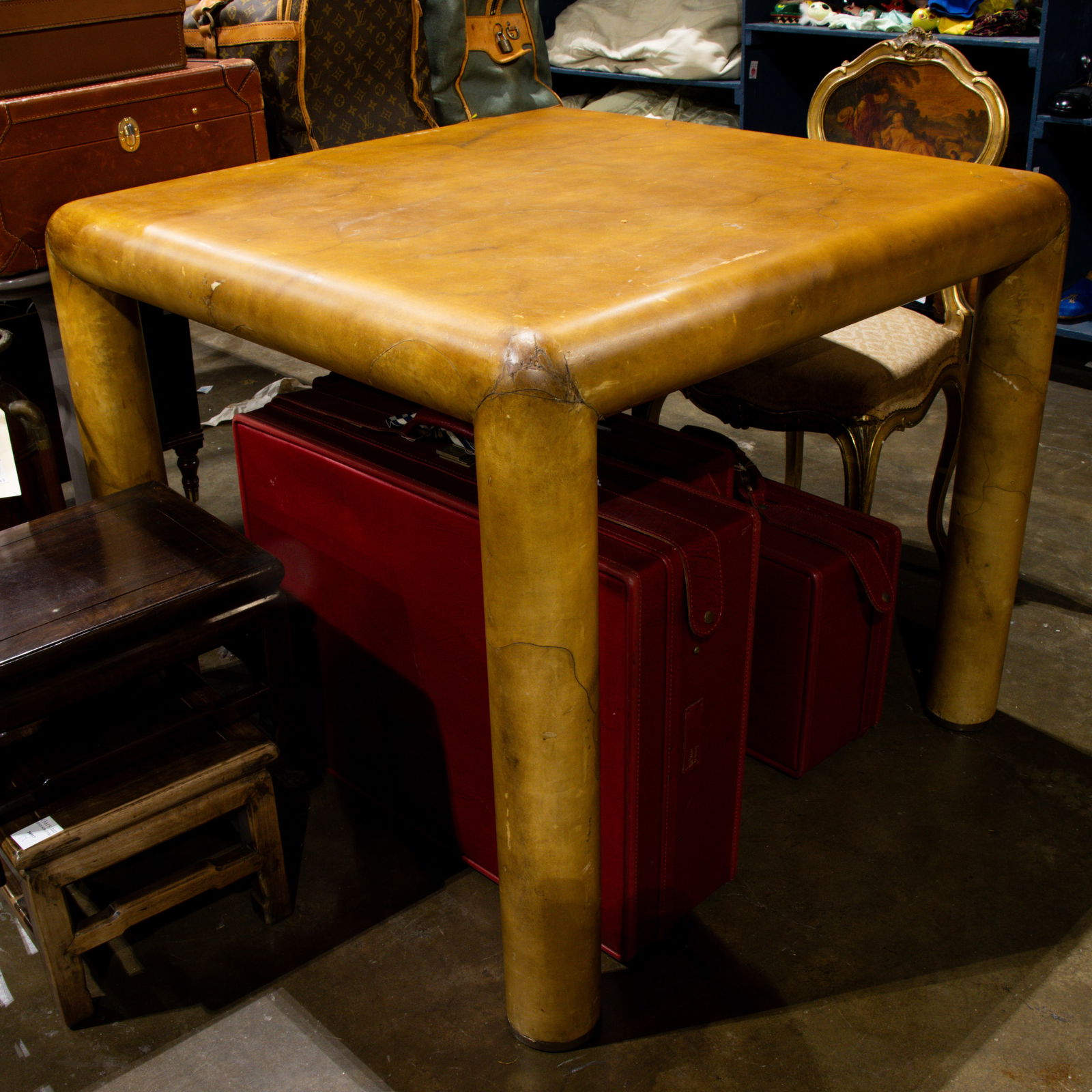 A Karl Springer (attrib) parchment/goat skin wrapped table: A Karl Springer (attrib) parchment/goat skin wrapped table, the square top rising on round legs, 30"h x 36"w