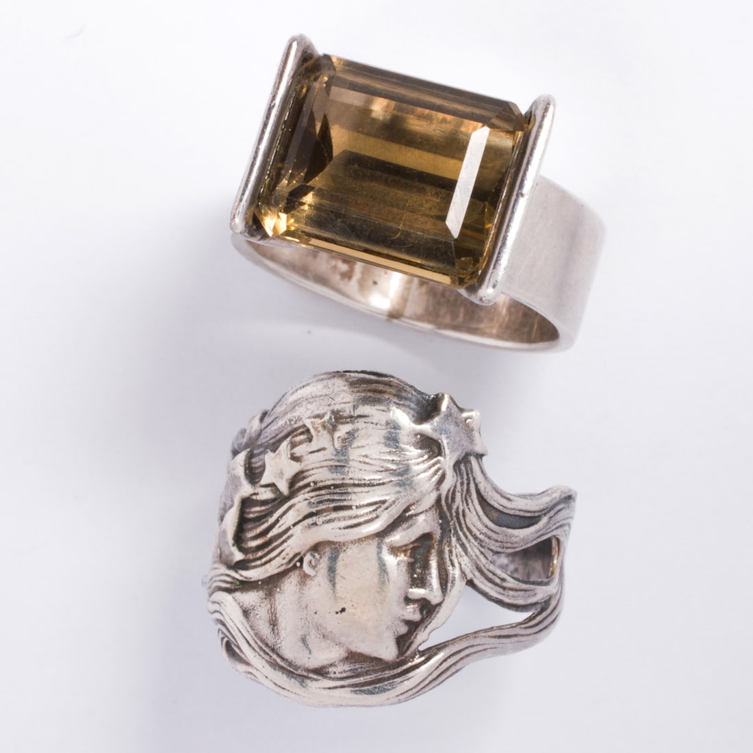 Two pairs of sterling silver rings: Two pairs of sterling silver ringsComprising one of art-noveau style, and one set with an emerald-cut smokey quartz measuring approximately 12.58 x 10.49 mm; sizes 8 1/2; gross weight: 12.50 grams