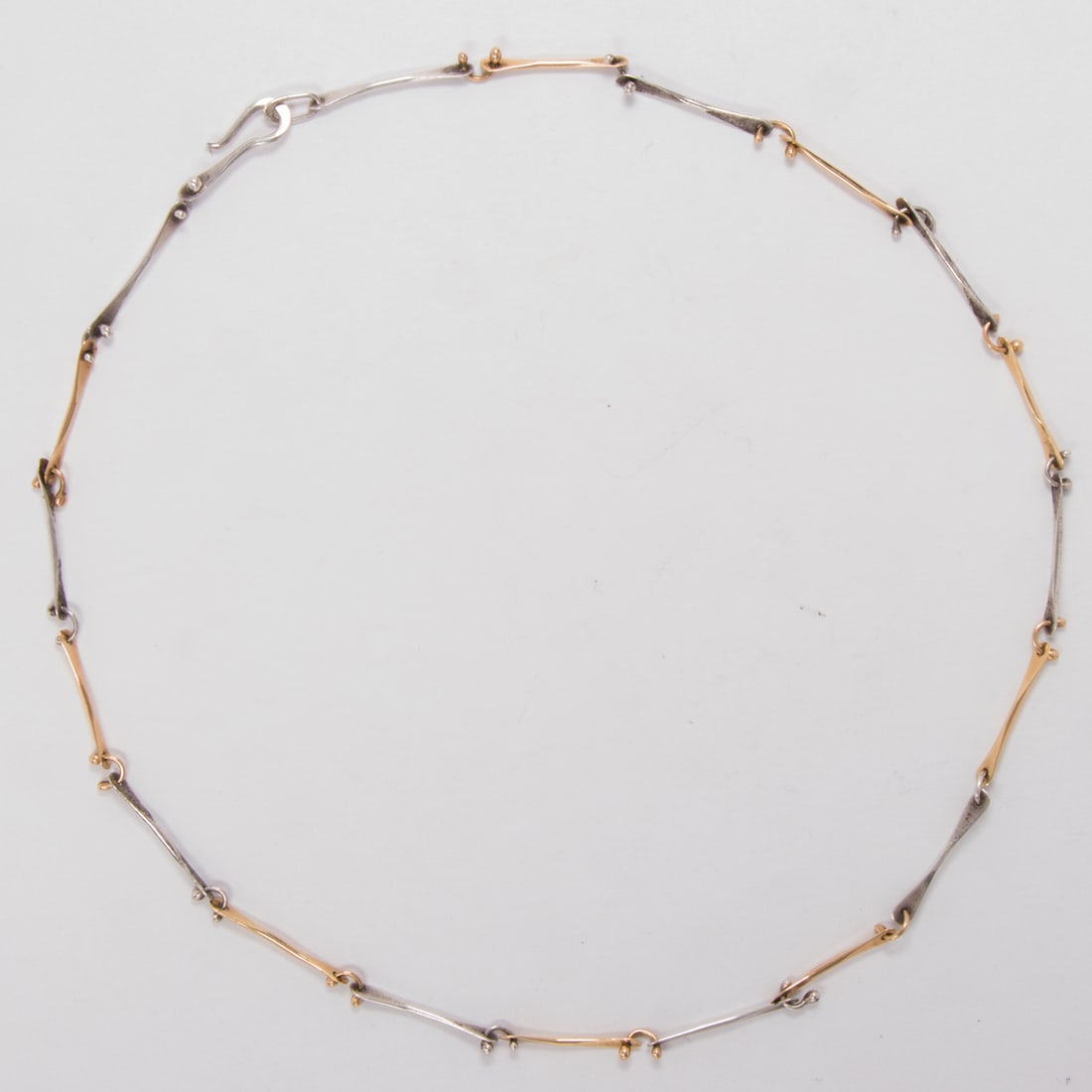 A sterling silver and 14k gold necklace: A sterling silver and 14k gold necklaceDesigned as a interspersed 3/4 inch sterling silver and 14k gold links; length: 17 1/2 in; 7.20 grams