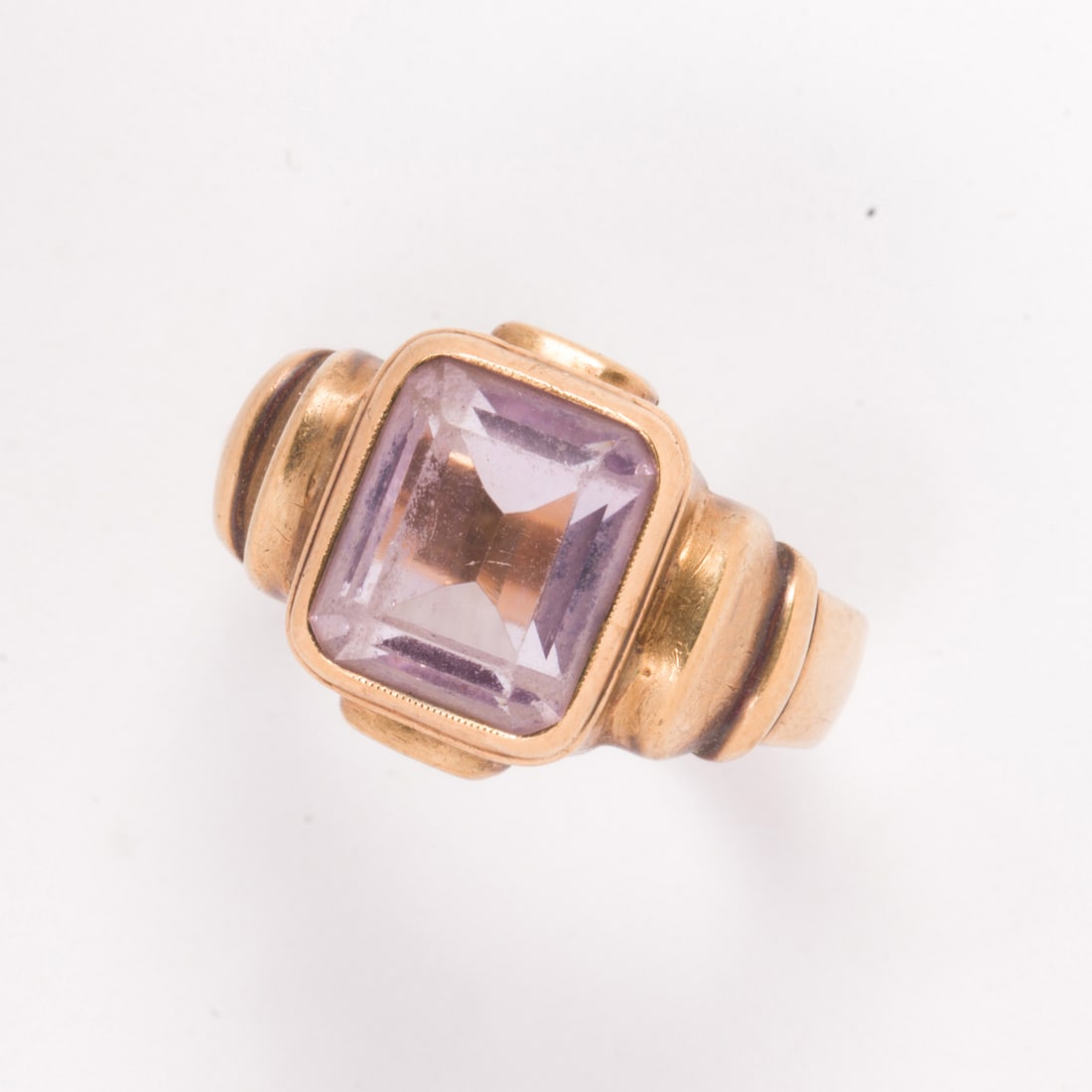 An amethyst and 10k gold ring: An amethyst and 10k gold ringCentering a rectangular step-cut, amethyst; 7.55 grams; size: 10 3/4