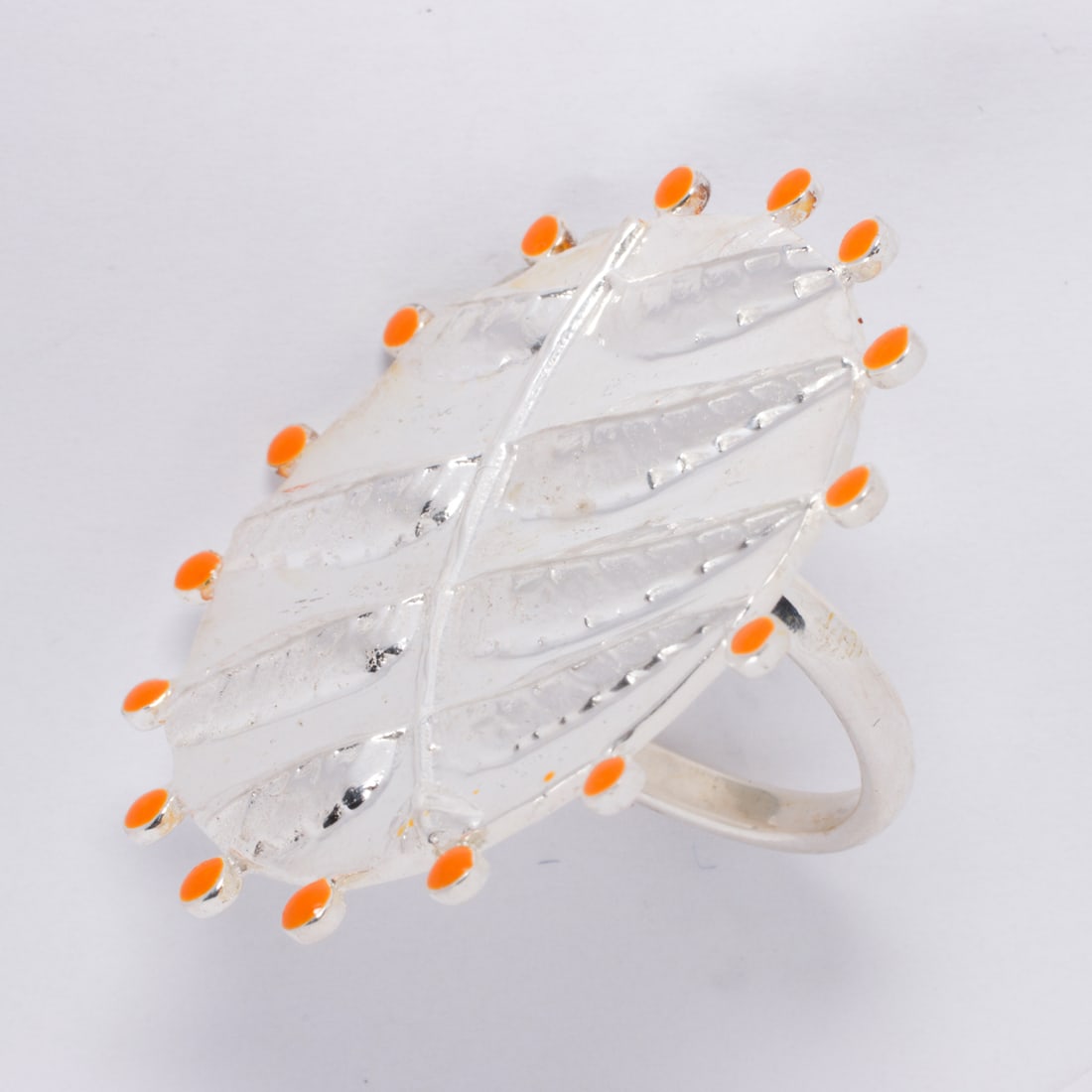 A silver-tone and enamel ring: A silver-tone and enamel ringDesigned as leaves, accented by orange enamel; size 7; 11.85 grams