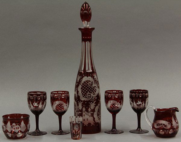 Bohemian ruby cut to clear articles, late 19th century: (lot of 7) Bohemian ruby on clear glass articles, late 19th century. Consisiting of a "Jeannie bottle" form decanter, four cordials, creamer, sugar and shot glass. Etched design depicts flowers, leave