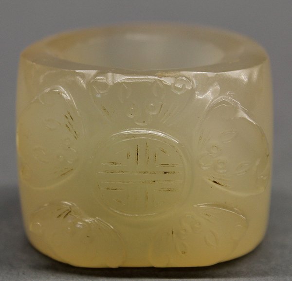 Chinese Agate Archer's Ring, Bats: Chinese carved agate thumb ring, featuring five bats surrounding a shou medallion, the semi-translucent tan colored matrix with minor mottled brown patches, 1.5"w