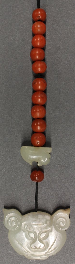 Chinese Jade Tiger Plaque and Beads: Chinese jade toggle, the celadon matrix shaped as a tiger head, strung together with a small jade fu-lion and carnelian beads, tiger: 1.6"w
