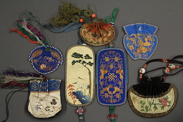Group of Chinese Sachet and Eyeglass Cases: (lot of 7) Chinese embroidered sachet and eyeglass cases: one couched with gourds on a blue ground; one of bats, endless knot and gourds on a pink peach form ground; one knotted with flowers on an ora