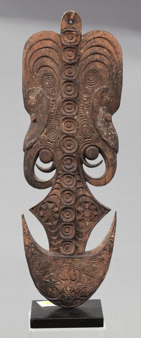 Papua New Guinea figural food storage hook: Papua New Guinea figural food storage hook. A finely and elaborately carved hook with two faces in profile having long noses and looking out to each side. Having all over carving of swirls and a face