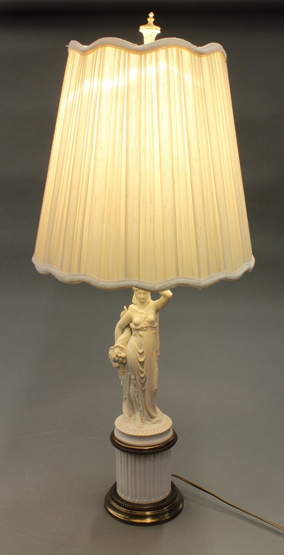 Continental style bisque lamp: Continental style bisque lamp, executed in the Classical taste, having a figural standard depicting a maiden, her right arm bearing a bountiful cornicopia and rising on a columnar plinth, base size 25