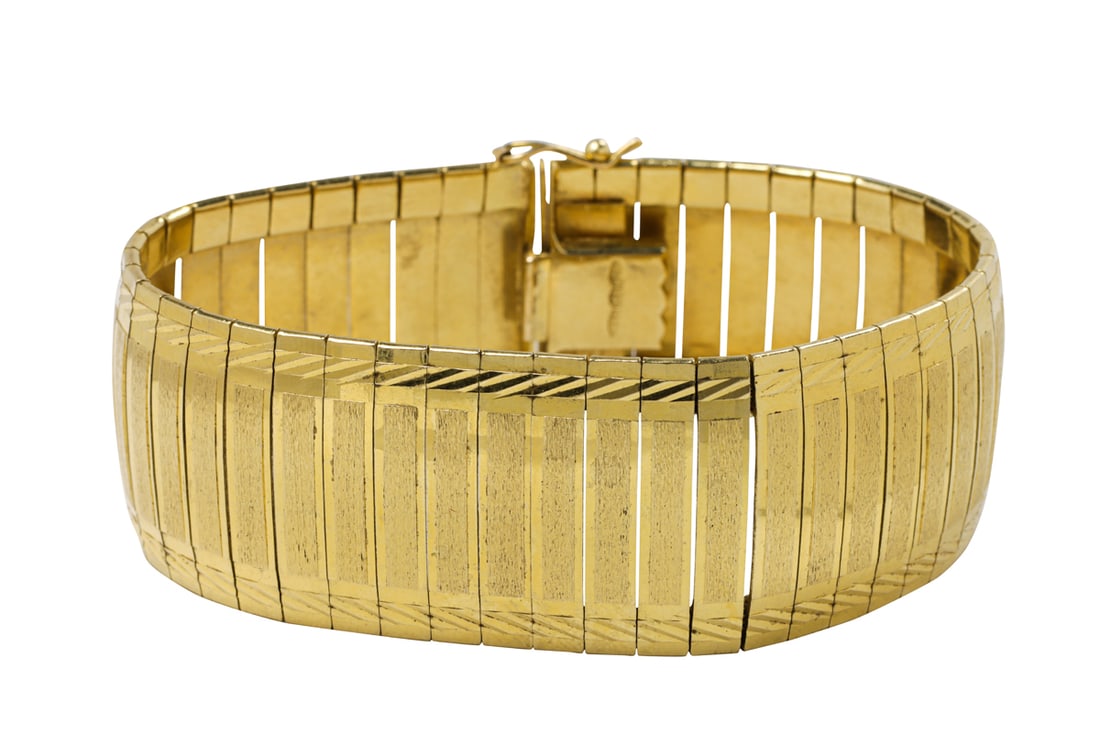 An 18k gold wide bracelet: An 18k gold wide braceletof flexible strap design; length: 7 1/2 in, width: 1 in; 67.00 grams