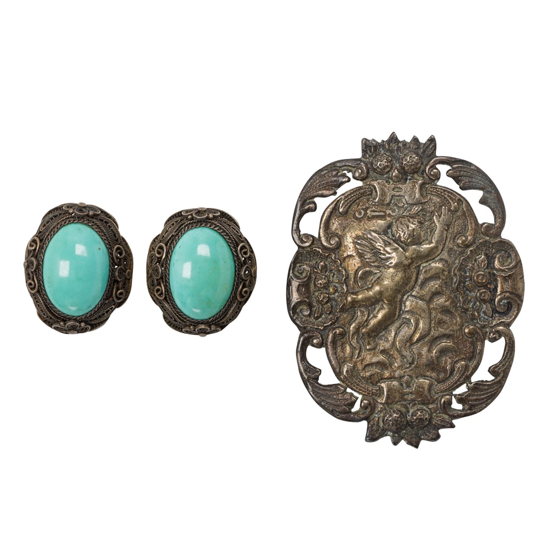 An antique silver buckle and pair of ear-clips: An antique silver buckle and pair of ear-clipsComprising one embossed silver belt buckle depicting a cherub, together with a pair of silver filigree ear clips set with oval-shaped turquoise cabochons