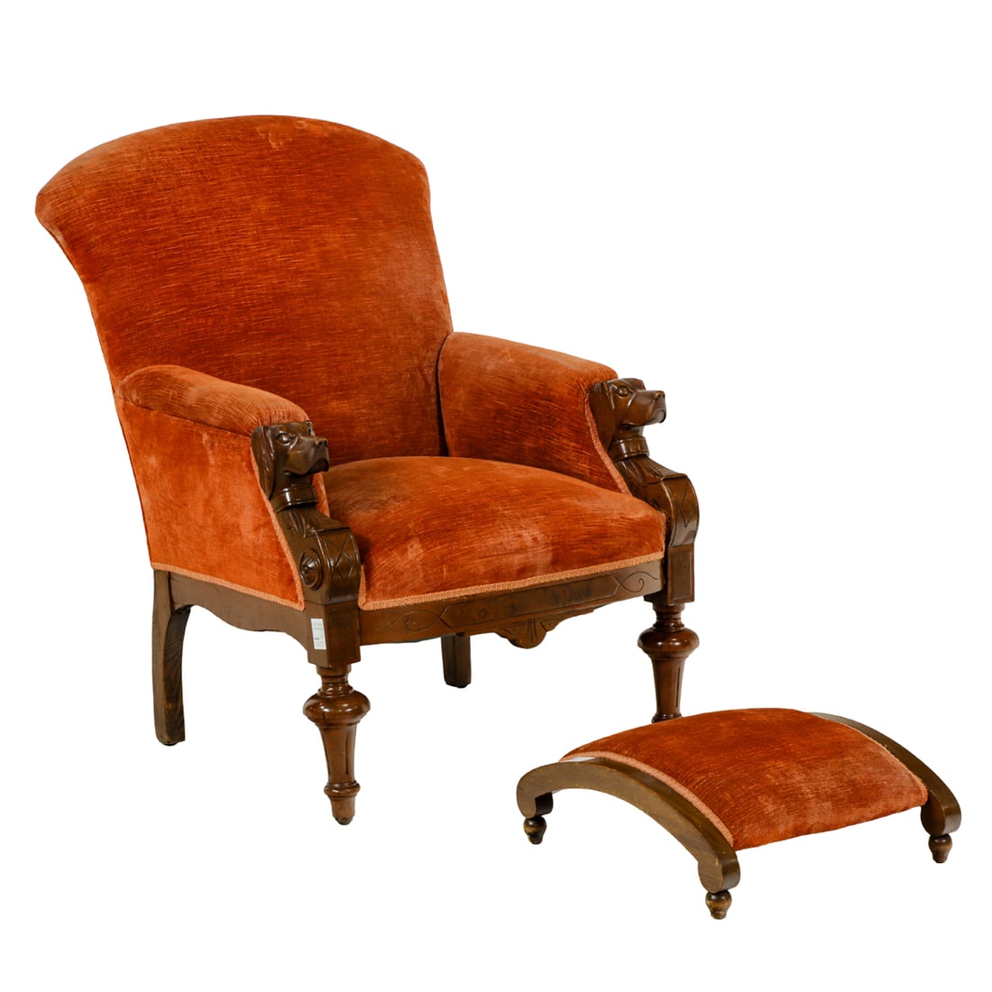 A Victorian Renaissance Revival armchair circa 1870: A Victorian Renaissance Revival armchair circa 1870, with carved dog head returns and rising on turned legs, together with an associated footstool, chair 38.5"h x 28.5"w x 20.5"d; stool 7"h x 16.5"w
