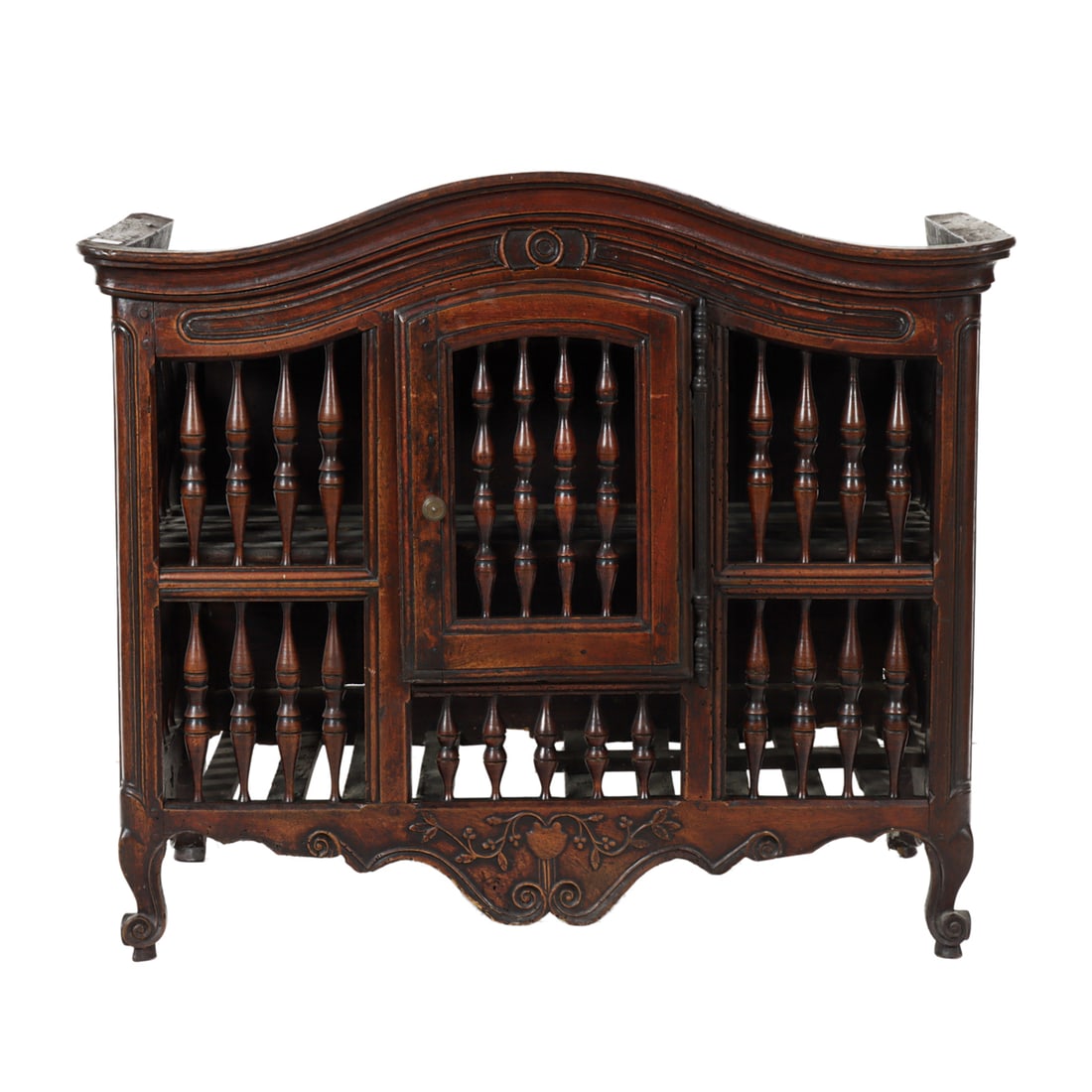 A French Provincial panettiere circa 1800: A French Provincial panettiere circa 1800, with a dome top above the spindle turned case having a single door, above the floral carved medallion, and rising on outswept legs, 37"h x 43"w x 23"d