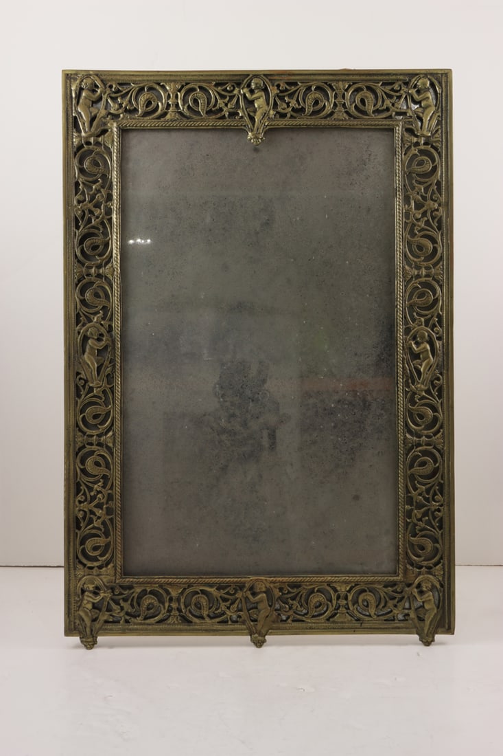 A late Victorian reticulated brass mirror: A late Victorian reticulated brass mirror, late 19th/early 20th century, the banded border incorporating figures among scrolls, 31.5"h x 21.25"w