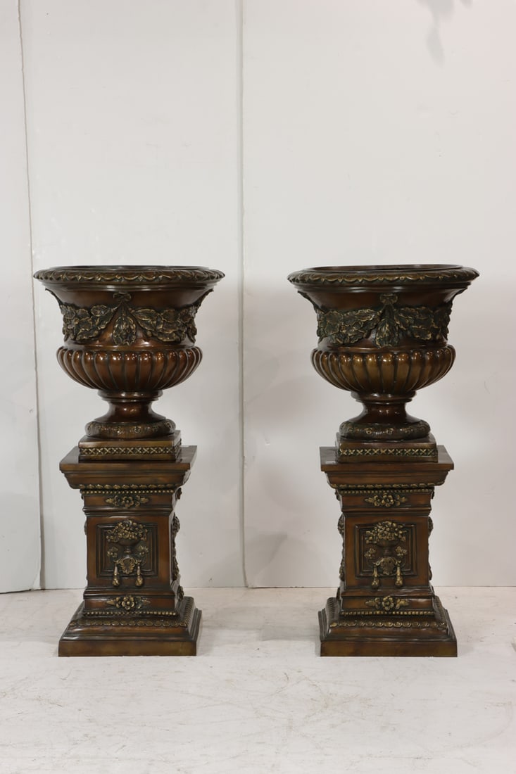 A large pair of Neoclassical style patinated bronze urns on pedestals: A large pair of Neoclassical style patinated bronze urns on pedestals, 49"h x 24"dia