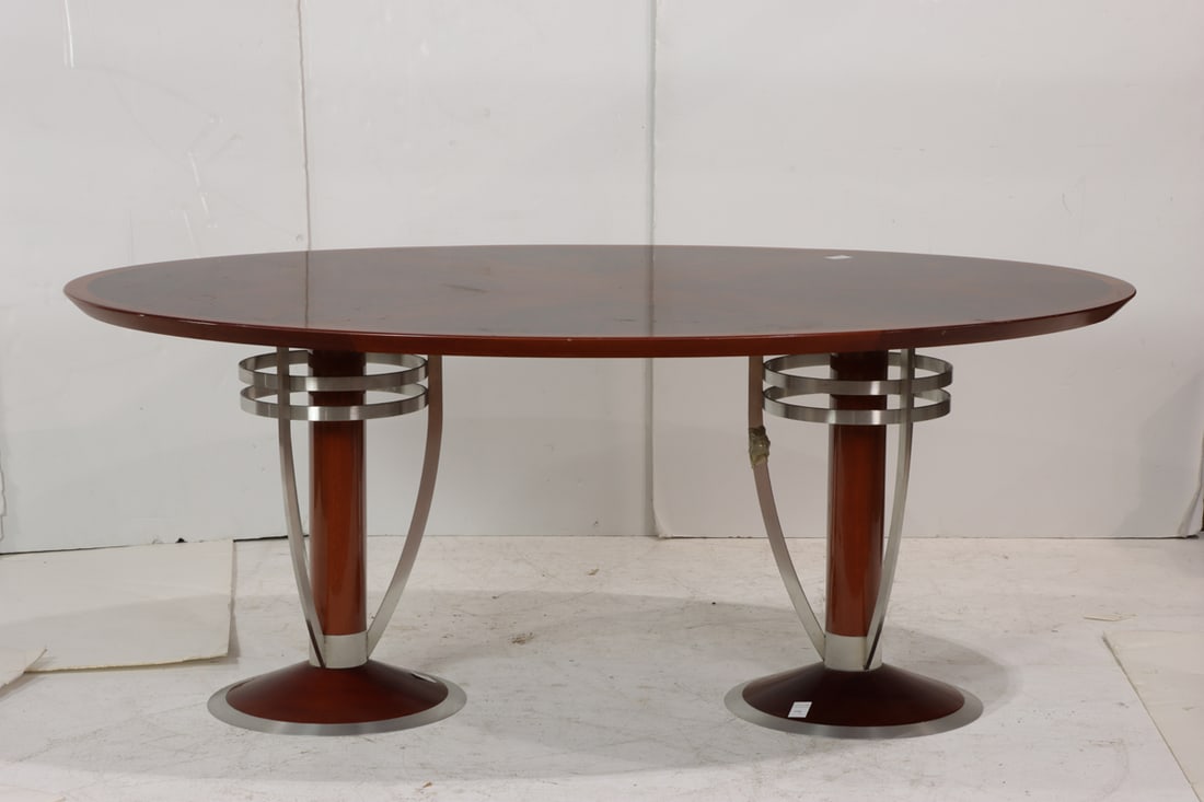 An Art Deco style double pedestal oval dining table: An Art Deco style double pedestal oval dining table, the highly figured lacquered top raised on brushed metal caged pedestal supports, 30"h x 72.5"dia