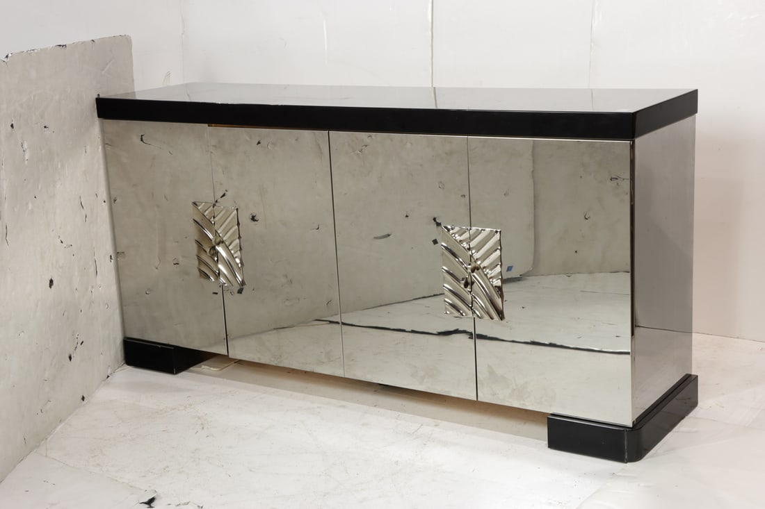 An Italian black lacquer and mirrored buffet: An Italian black lacquer and mirrored buffet, the four doors opening to arrangement of cubbies and drawers, 40"h x 80.5"w x 20.75"d