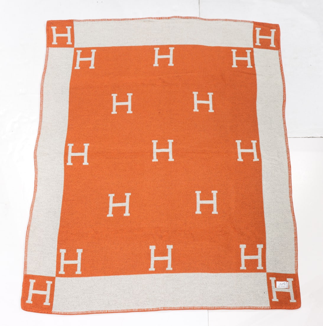 An Hermes Avalon cashmere blend throw blanket: An Hermes Avalon cashmere blend throw blanket, jacquard-woven in the signature "H" checkerboard pattern finished with a coordinated blanket stitch edge, applied factory label, 65"h x 50"w