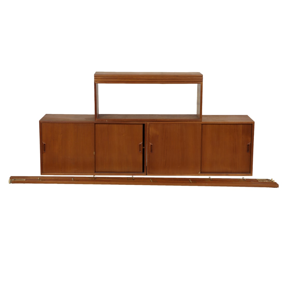 A Danish modern modular wall unit: A Danish modern modular wall unit, mid-20th century, composed of (2) cabinets with sliding doors; (1) glazed display cabinet; (3) floating shelves and (4) tension supports, cabinet: 20.5"h x 39"w x