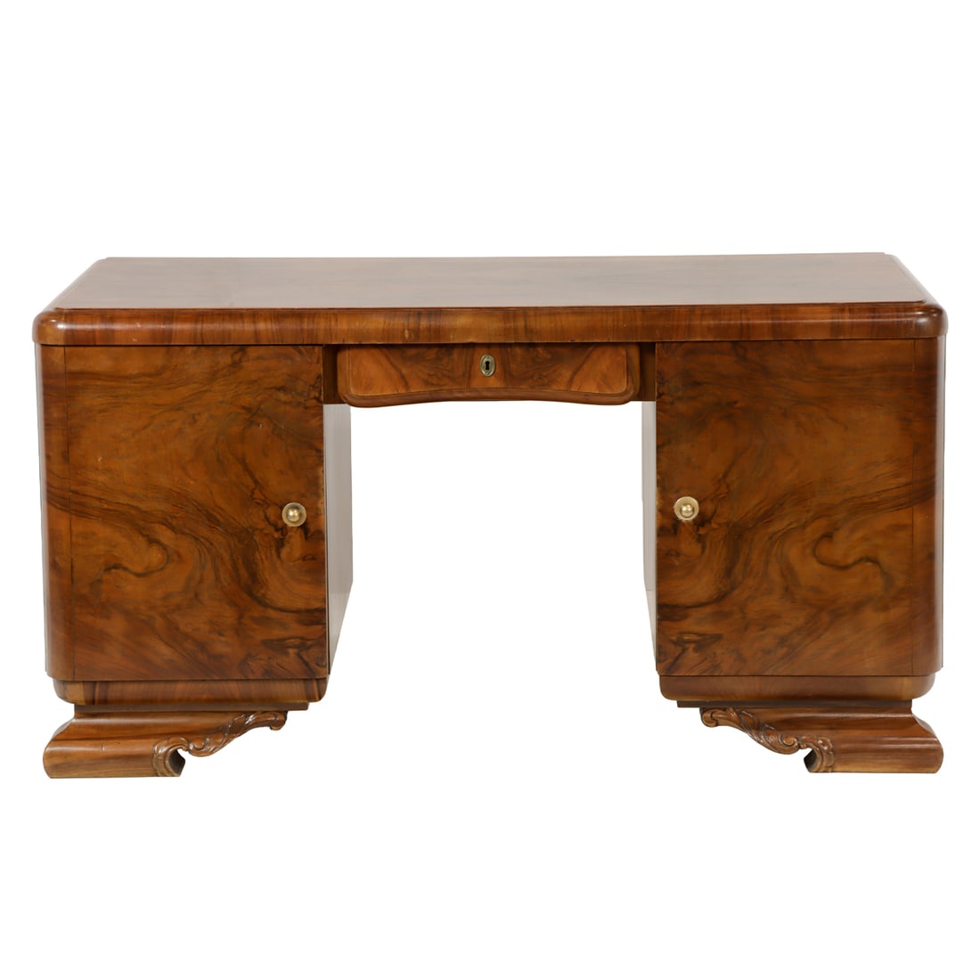 An Art Deco executive desk circa 1940: An Art Deco executive desk circa 1940, the walnut case with two doors, one opening to slide out shelves, and rising on carved feet, 31.5"h x 59"x 29"d