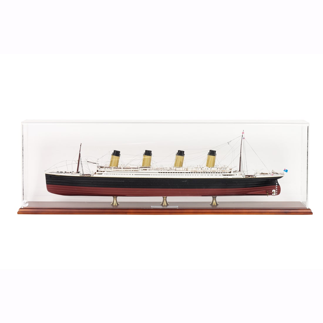 A ship model of the R.M.S. Titanic: A ship model of the R.M.S. Titanic, featuring a fully rigged mast and detailed deck machinery, raised on a fitted stand with a brass-tone nameplate, housed within an acrylic vitrine, overall 10"h x