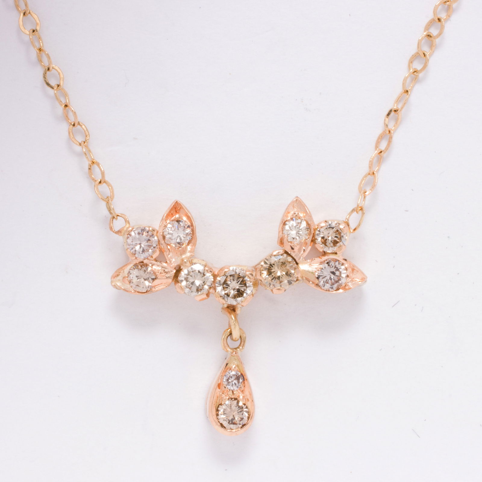 A diamond and 14k gold necklace: A diamond and 14k gold necklaceOf garland style, set with 11 round brilliant-cut diamonds weighing a total of 0.50 grams; length: 20 1/4 in; 3.80 grams