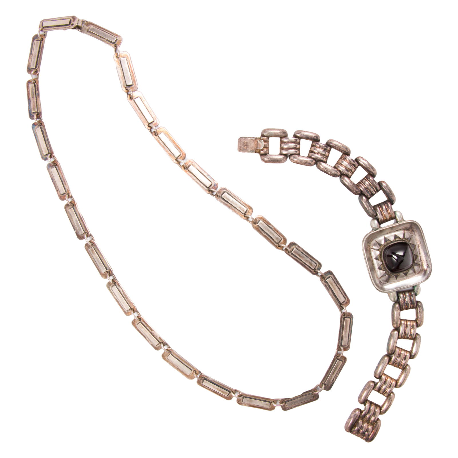 A garnet and silver bracelet and Taxco necklace: A garnet and silver bracelet and Taxco necklaceThe bracelet set with with a sugarloaf garnet cabochon measuring 14.15 mm across, together with fancy-link Taxco necklace; bracelet length: 7 1/2 in;