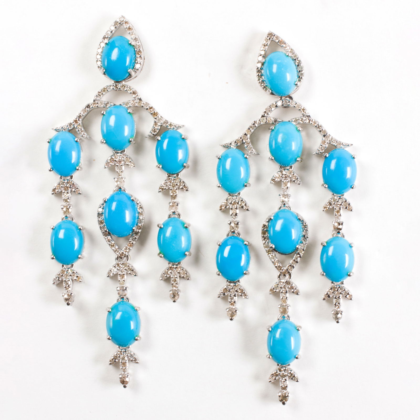 A pair of turquoise, diamond, and sterling silver earrings: A pair of turquoise, diamond, and sterling silver earringsOf chandelier design, set with eight oval-cut turquoise cabochons weighing a total of 17.99 carats, accented by round-cut diamonds weighing a