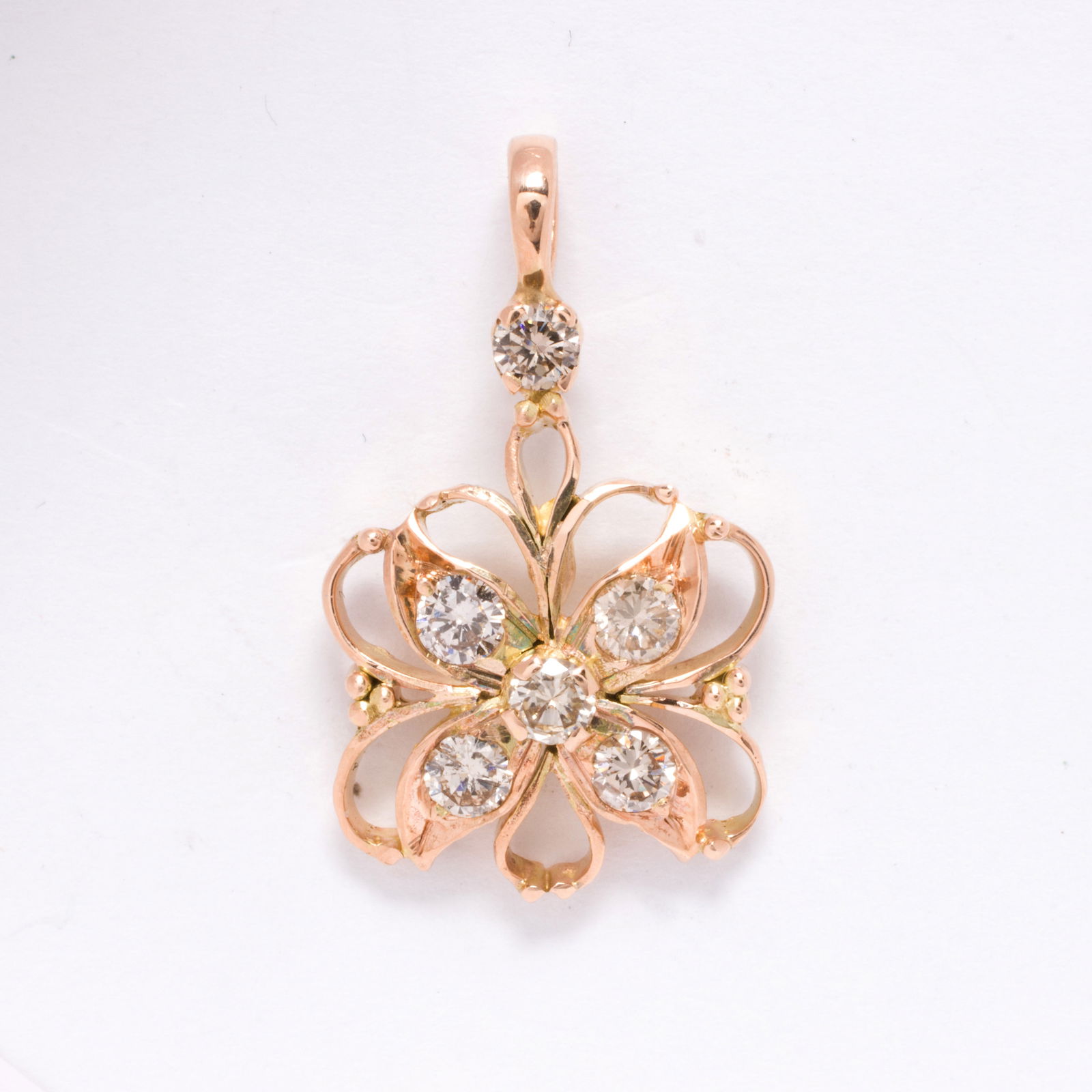 A diamond and 14k gold pendant: A diamond and 14k gold pendantOf floral motif, set with six round brilliant-cut diamonds; length: 1 1/8 in; 2.50 grams