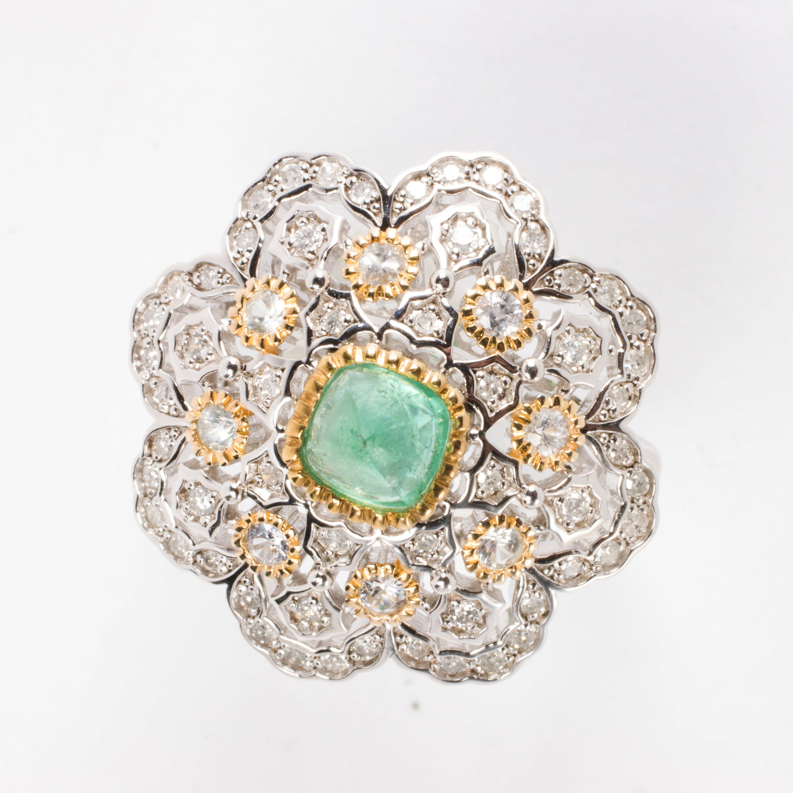 An emerald, diamond, sapphire, and sterling silver ring: An emerald, diamond, sapphire, and sterling silver ringCentering a sugarloaf emerald cabochon weighing 0.92 carats, framed within a lattice of round-cut diamonds and sapphires; size 7 3/4; 7.70 grams
